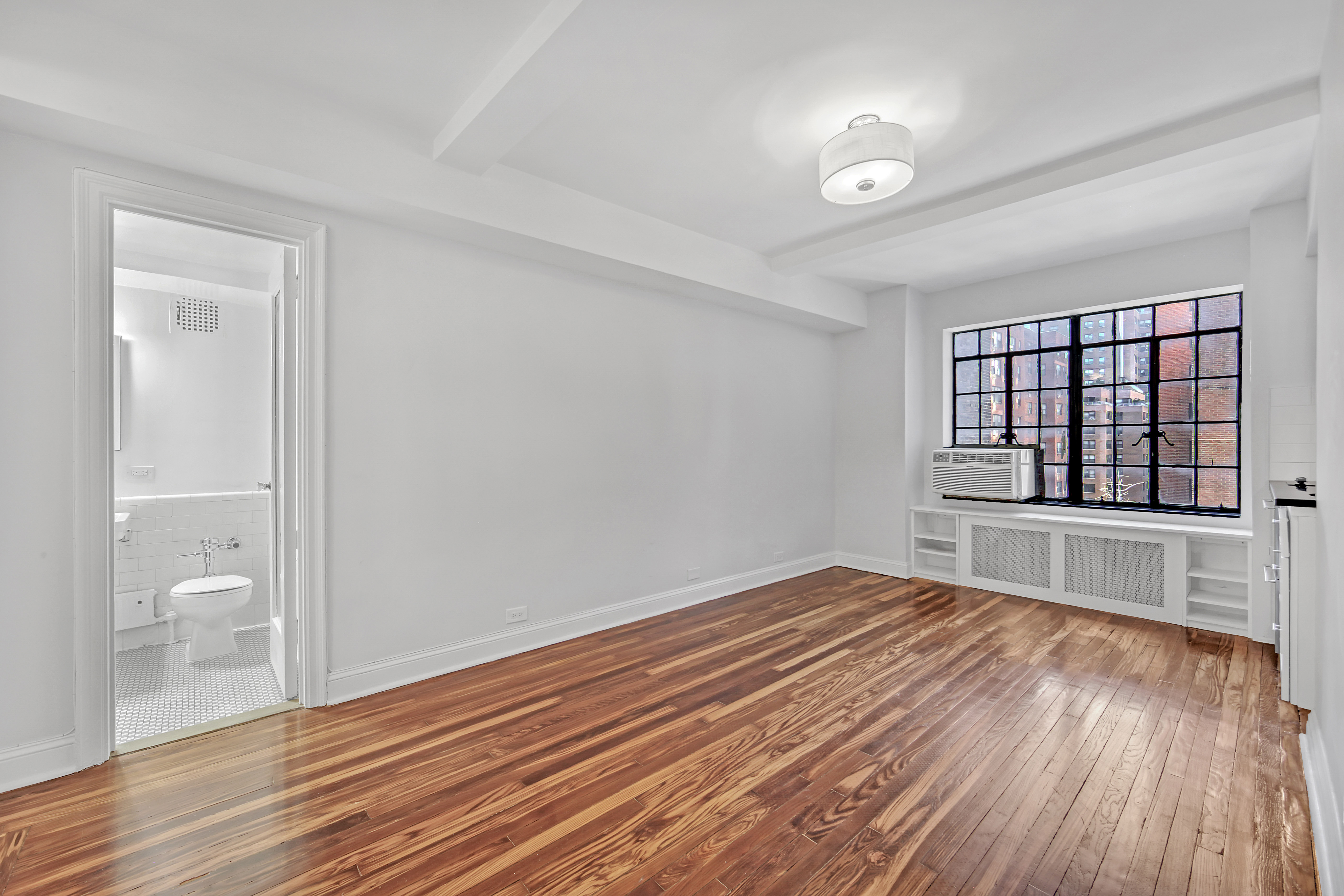 wooden floor in an empty room with a window