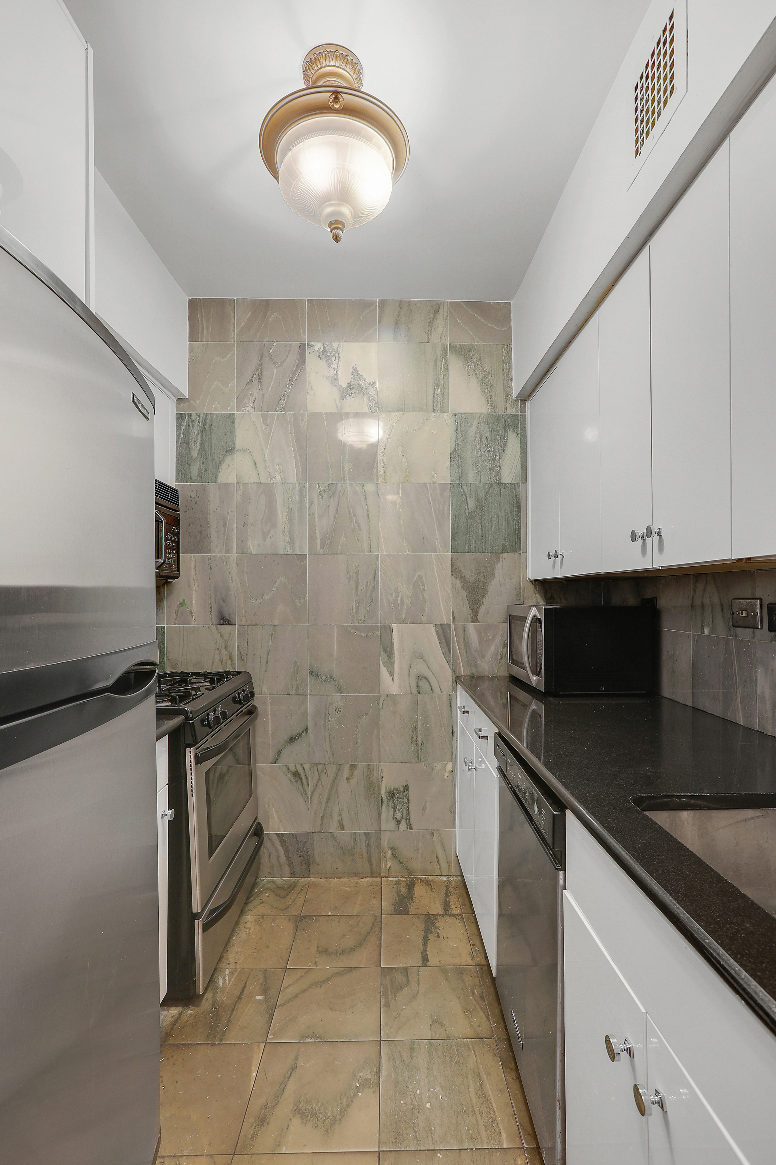 100 West 57th Street, Unit 15N Manhattan, NY 10019 - Photo 4 of 9 a kitchen with stainless steel appliances granite countertop a sink and a stove