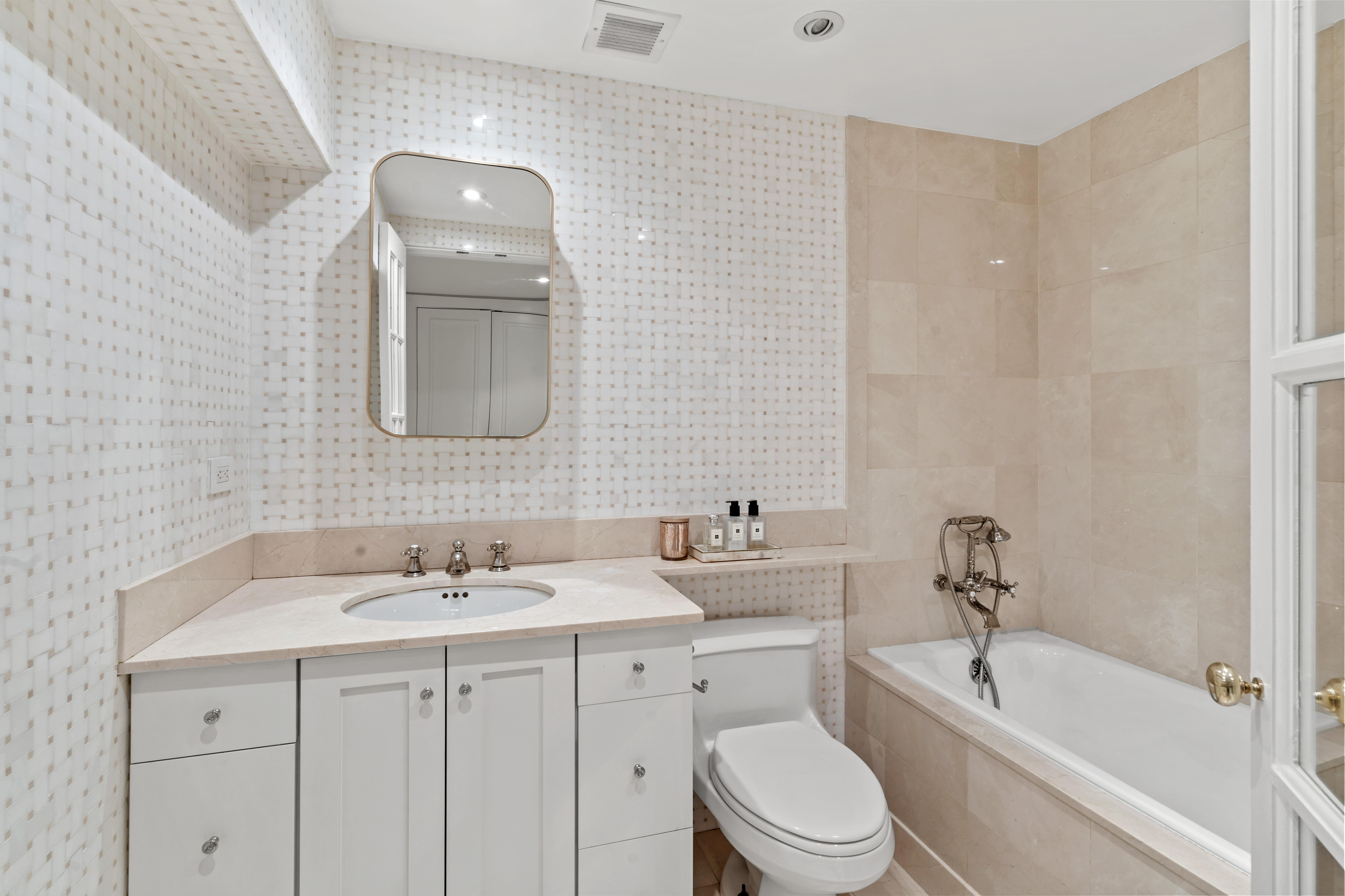 240 Centre Street, Unit 2N Manhattan, NY 10013 - Photo 10 of 16 a bathroom with a toilet a sink a mirror a bathtub and vanity