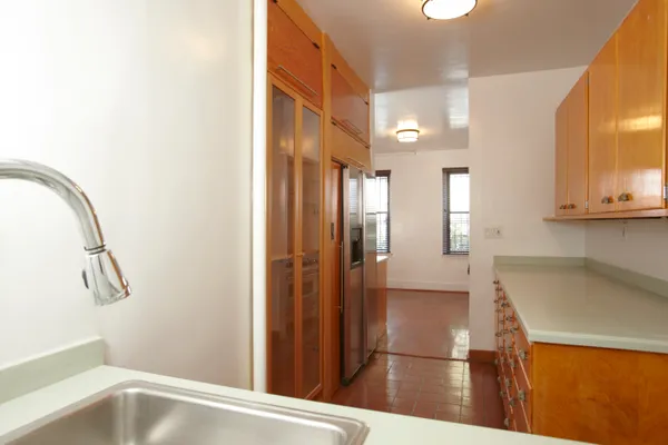 a kitchen with stainless steel appliances wooden floor sink and wooden cabinets