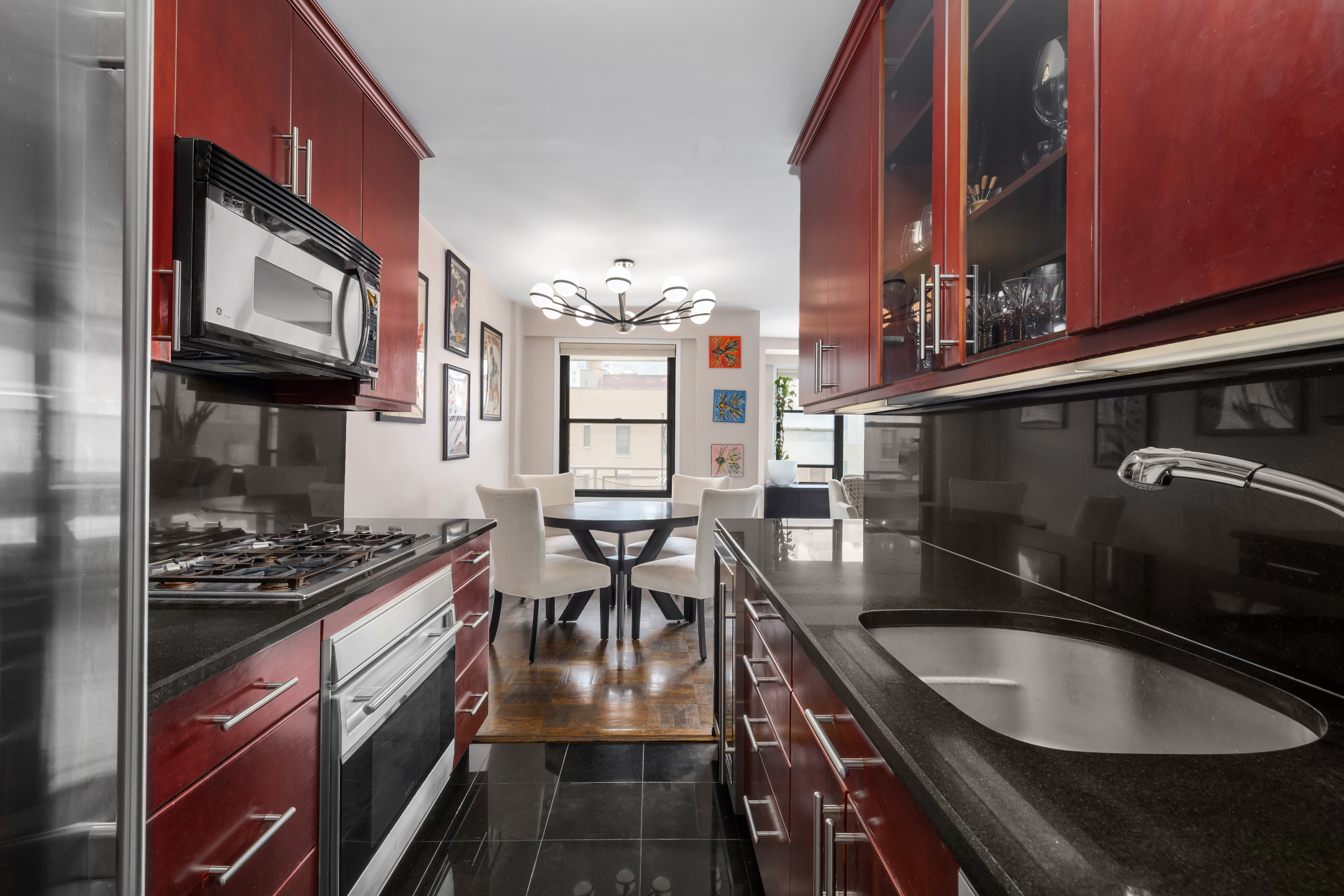 505 East 79th Street, Unit 7L Manhattan, NY 10075 - Photo 4 of 9 a kitchen with granite countertop a sink a stove and cabinets