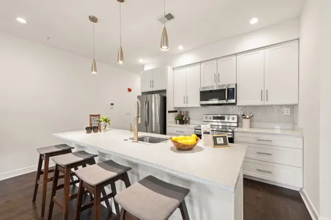 a kitchen with a sink a stove a dining table and chairs