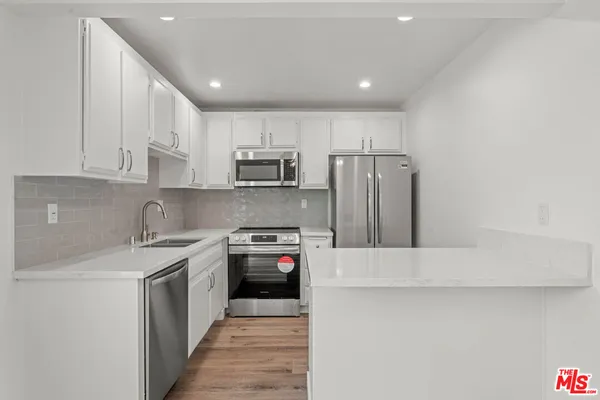 a kitchen with stainless steel appliances granite countertop a refrigerator sink and stove