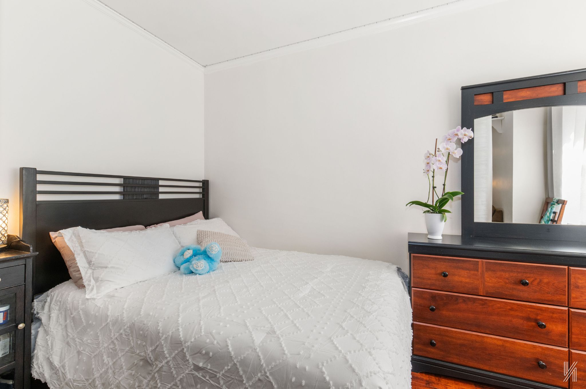 39-30 52nd Street, Unit 5E Queens, NY 11377 - Photo 5 of 15 a bedroom with a bed and a potted plant