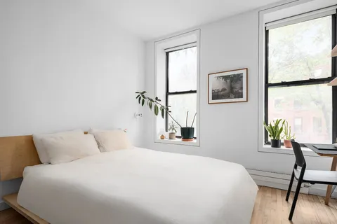 a bedroom with a bed and a painting on the wall