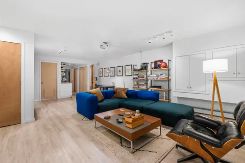 a living room with furniture and a wooden floor