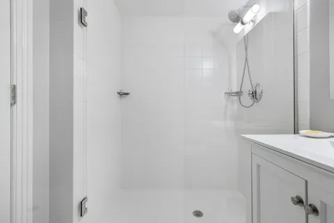 a bathroom with a shower a mirror and a sink