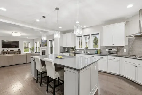 a large kitchen with kitchen island a dining table and chairs
