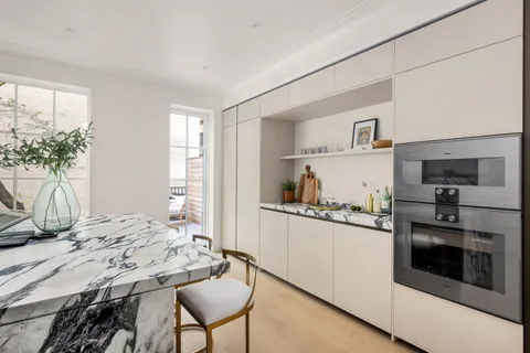 a kitchen with granite countertop white cabinets and stainless steel appliances