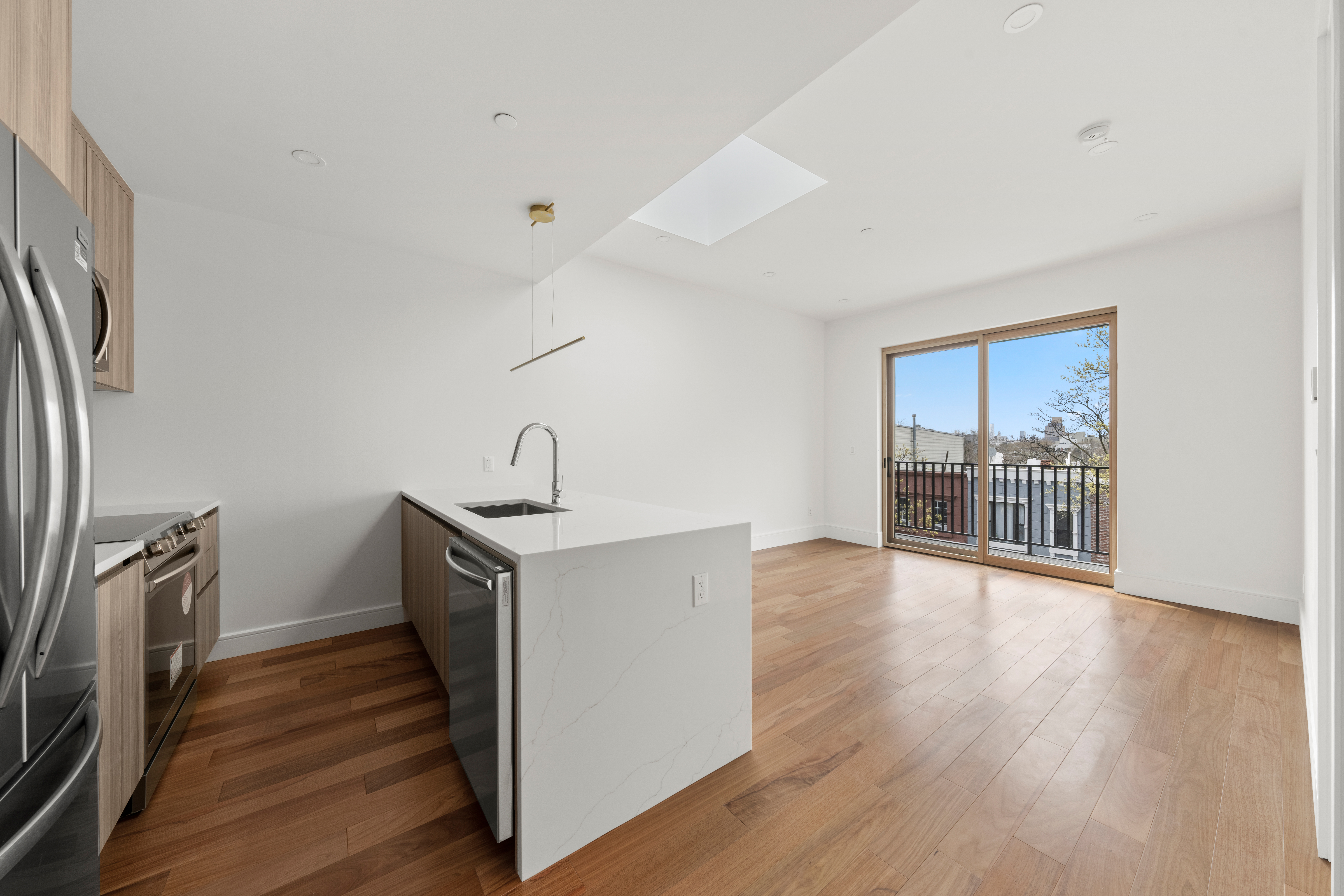 82 Cooper Street, Unit 3A Brooklyn, NY 11207 - Photo 12 of 17 a view of a kitchen with a sink wooden floor and a window