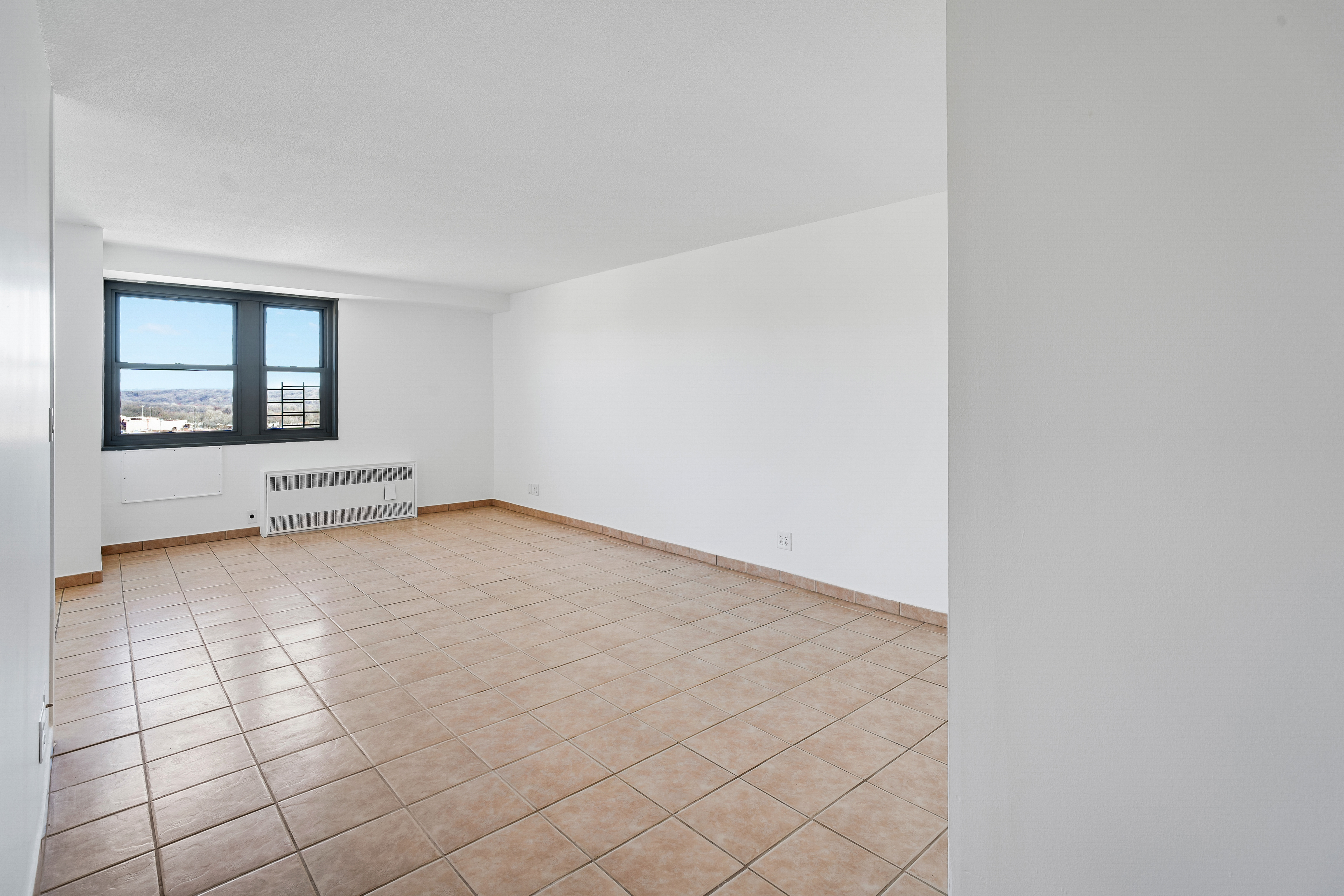 290 West 232nd Street, Unit 18B Bronx, NY 10463 - Photo 4 of 16 an empty room with windows