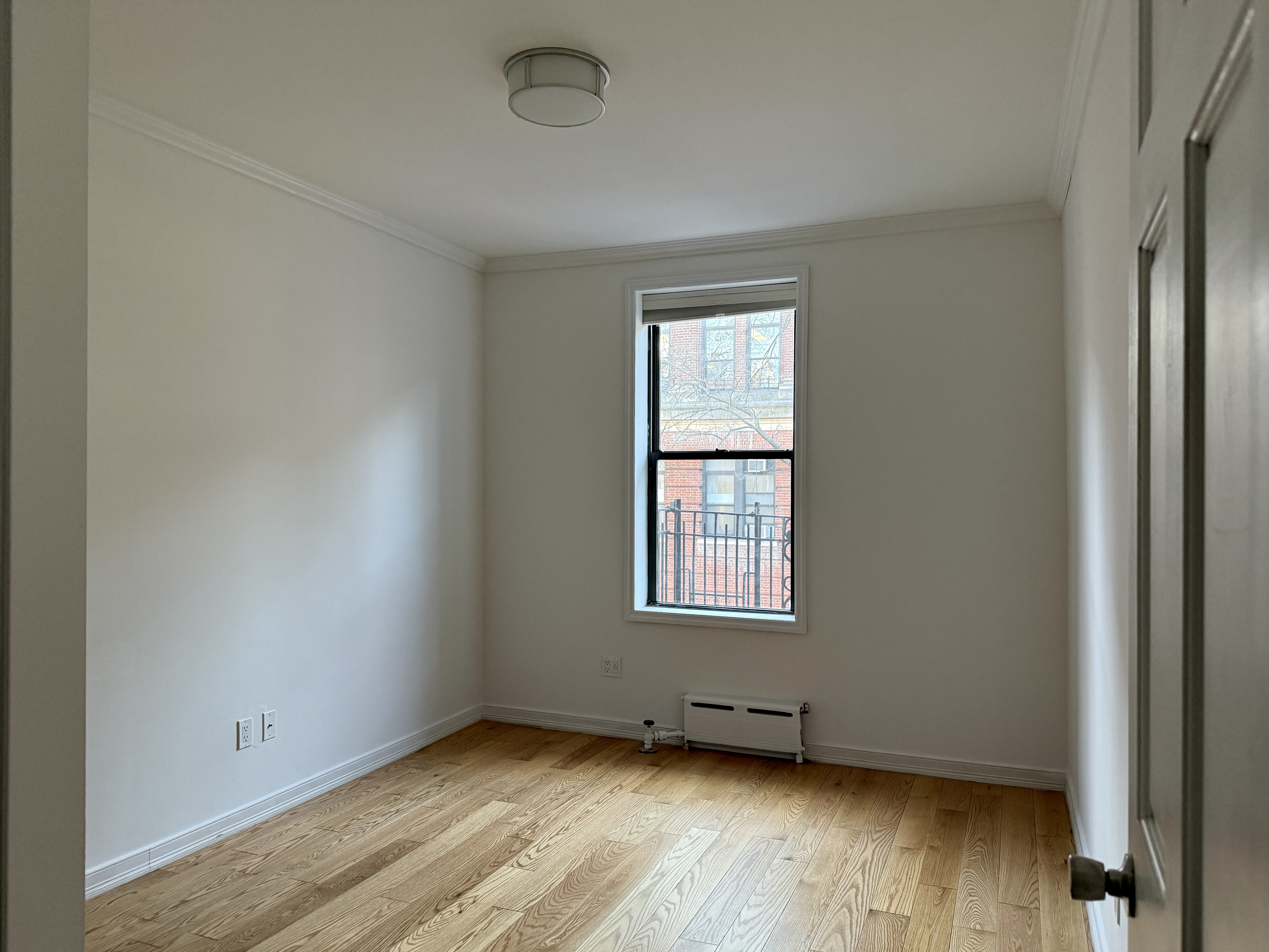 573 6th Street Brooklyn, NY 11215 - Photo 6 of 11 an empty room with wooden floor and windows