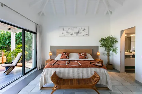 a bed sitting in a bedroom next to a window