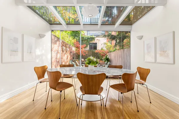a dining room with wooden floor glass table and chairs