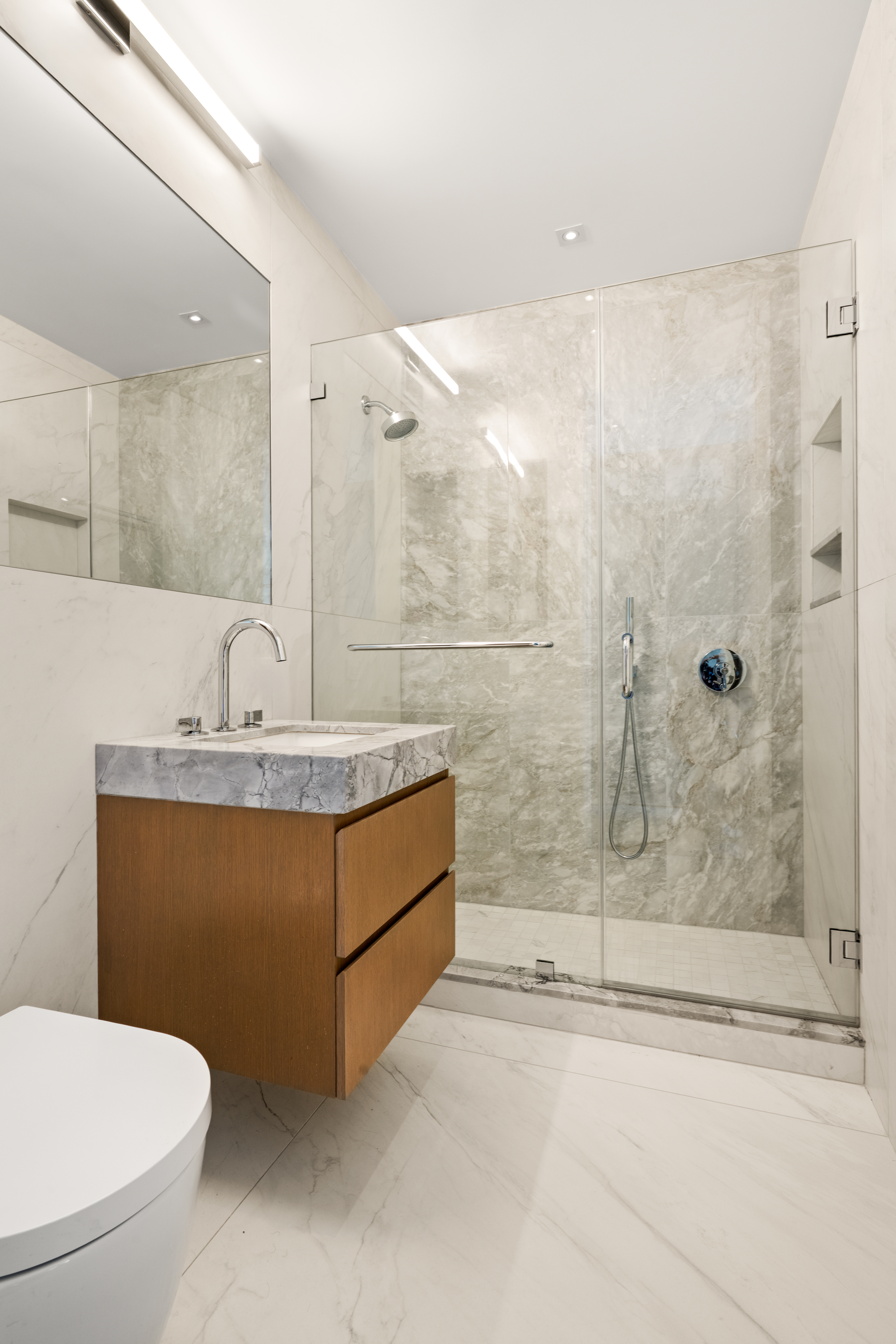 303 East 57th Street, Unit 44G Manhattan, NY 10022 - Photo 10 of 19 a bathroom with a sink a toilet and shower