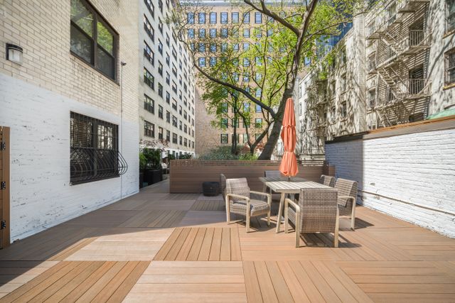 315 East 65th Street, Unit 1A Manhattan, NY 10065 - Photo 9 of 12 a view of a patio with table and chairs and couches with wooden floor and fence