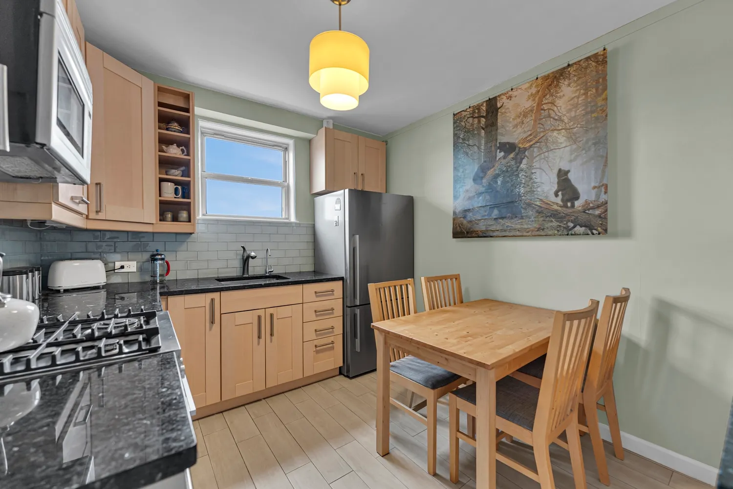 a kitchen with stainless steel appliances granite countertop a stove a sink and a refrigerator