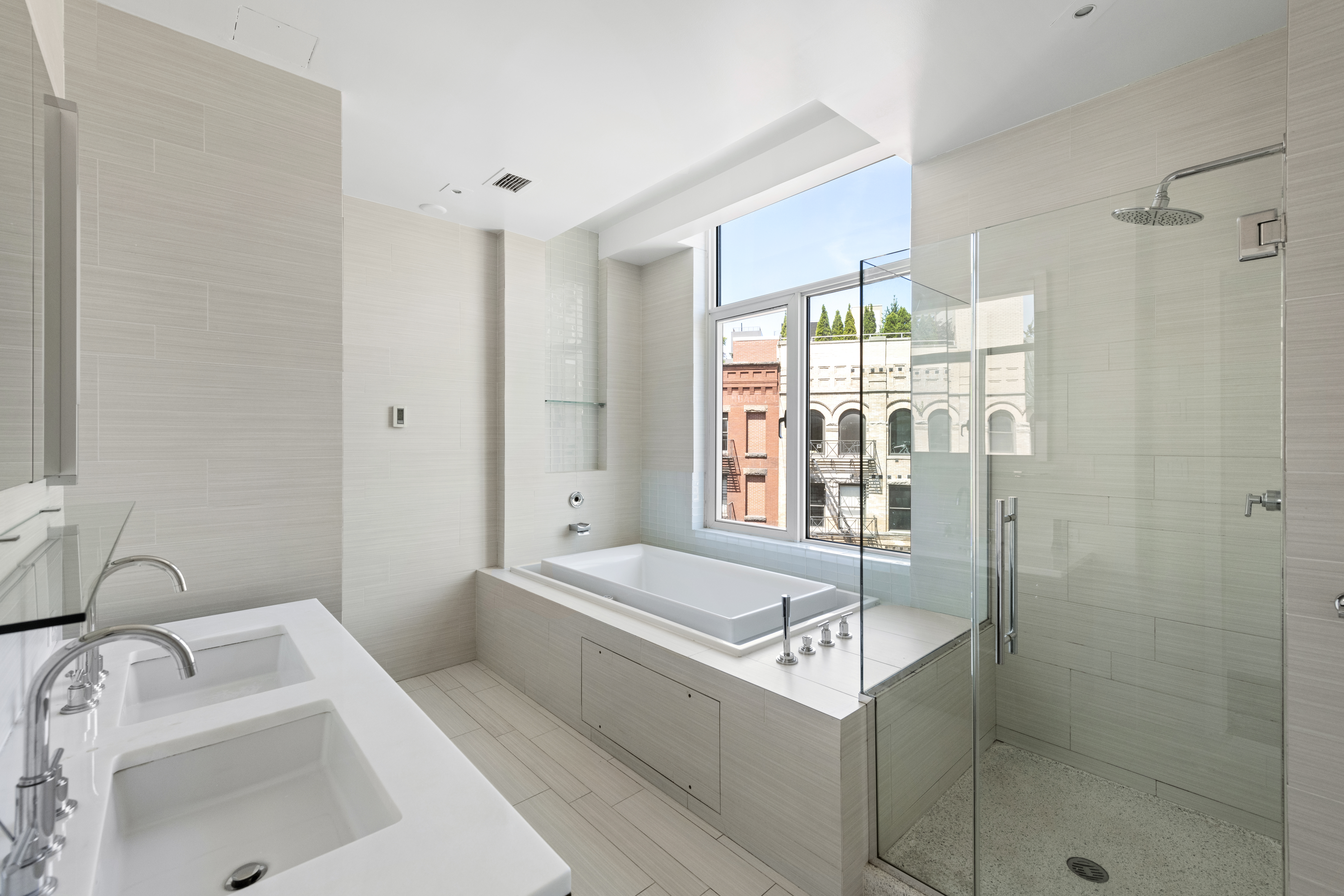 475 Greenwich Street, Unit PHN Manhattan, NY 10013 - Photo 13 of 28 a bathroom with a tub sink and shower