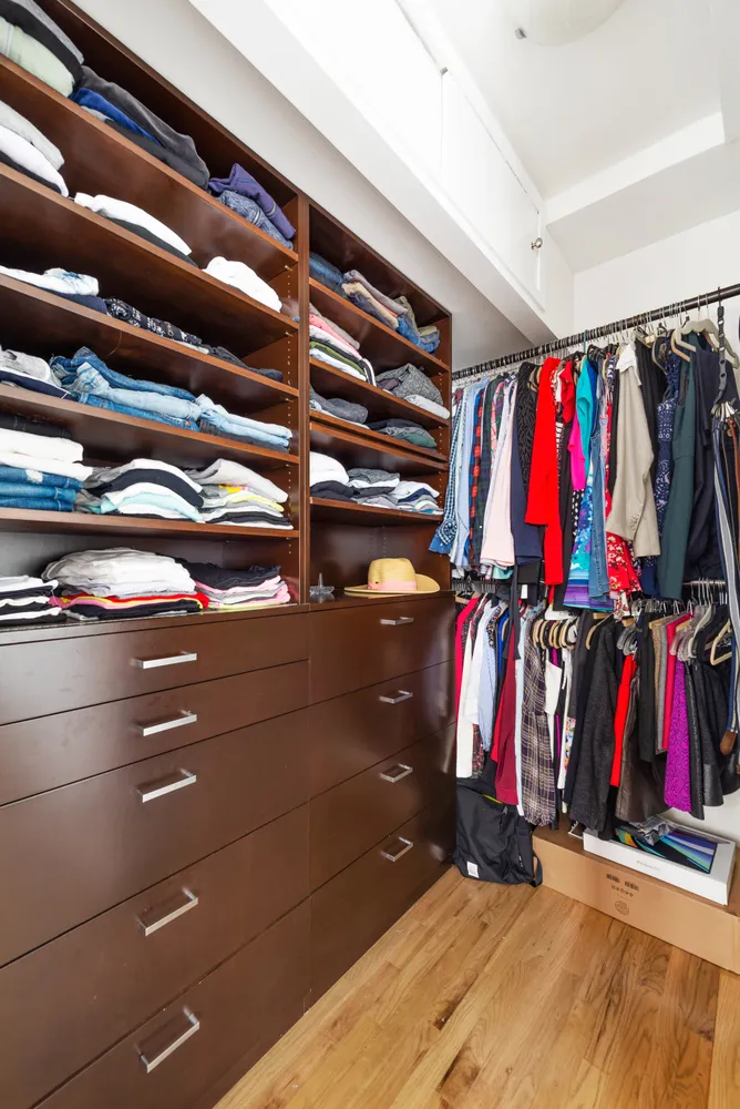 a view of walk in closet with clothes and shoes