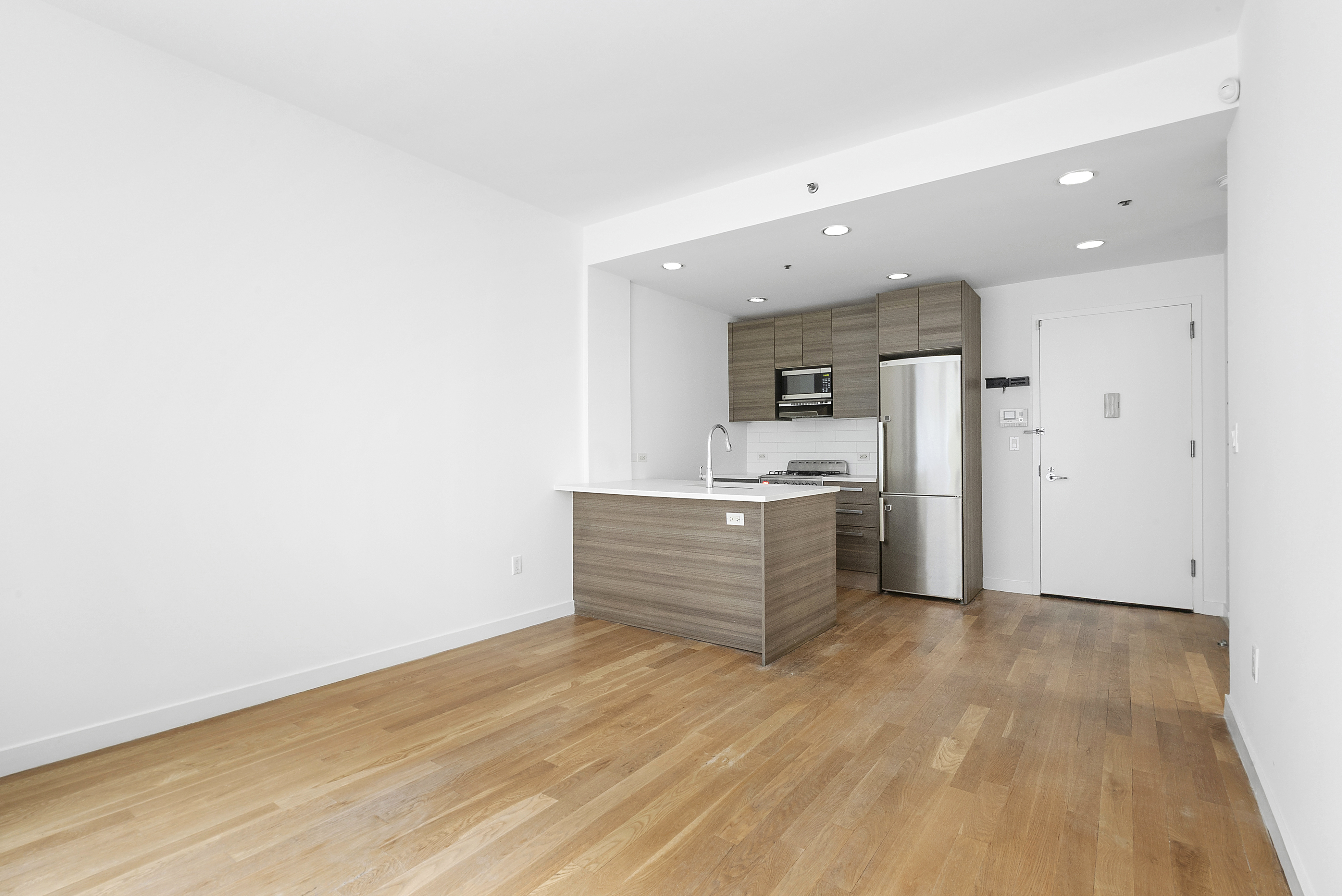 306 West 116th Street, Unit 1B Manhattan, NY 10026 - Photo 7 of 14 a view of a kitchen with white cabinets and wooden floor