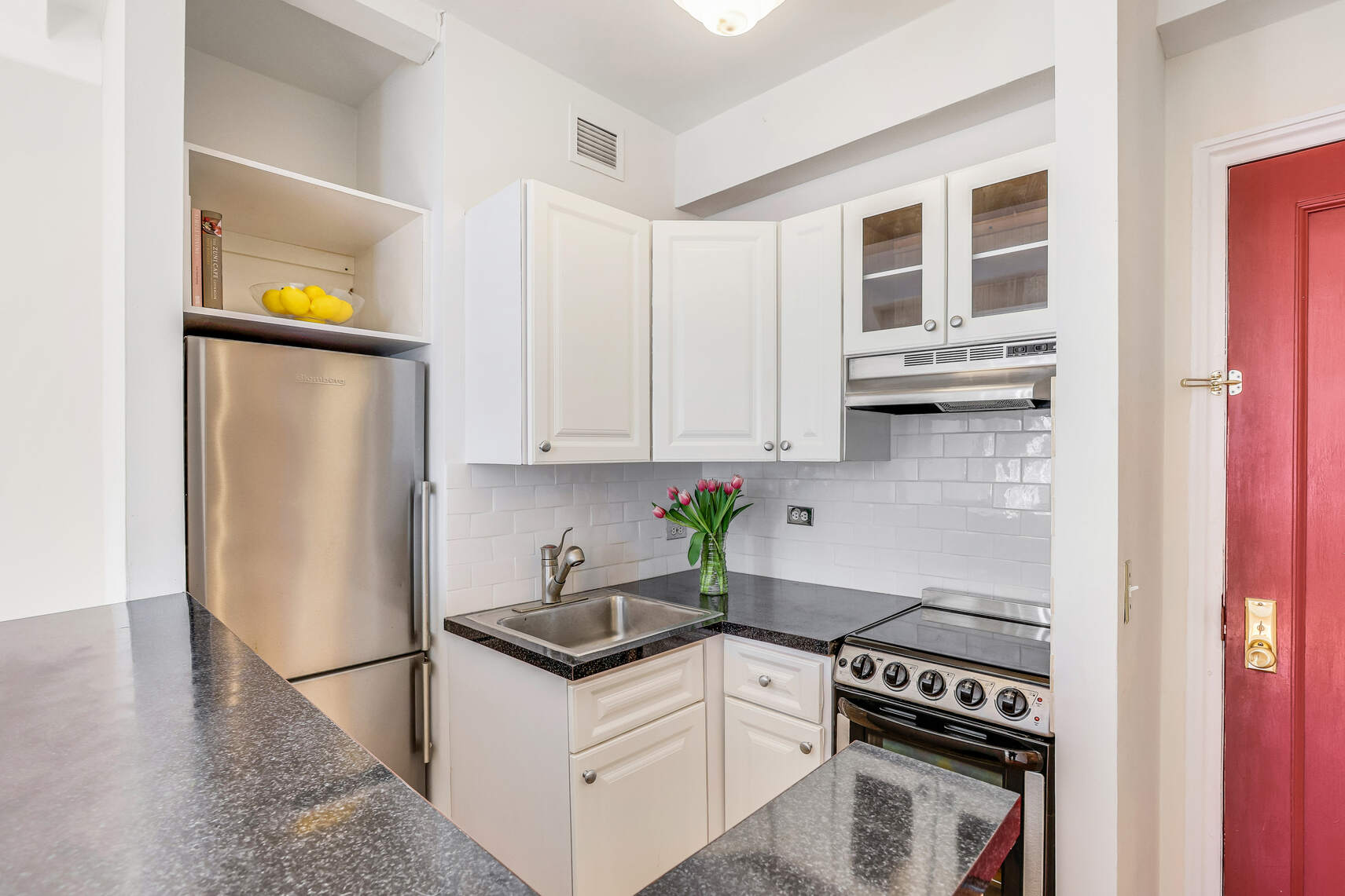 23 West 73rd Street, Unit 1405A Manhattan, NY 10023 - Photo 5 of 9 a kitchen with stainless steel appliances a stove a refrigerator and cabinets