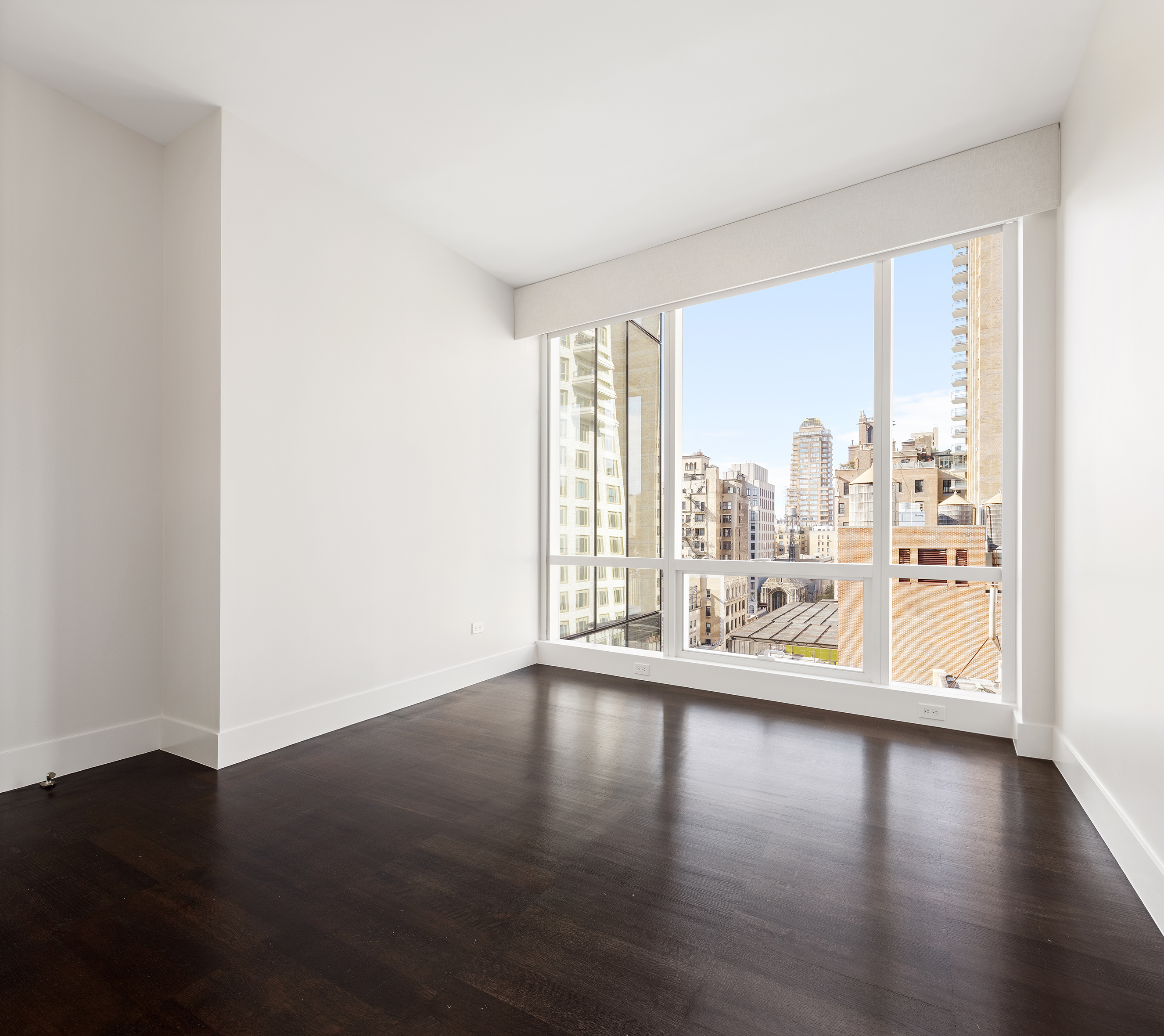 151 East 85th Street, Unit 14A Manhattan, NY 10028 - Photo 8 of 14 a view of an empty room with wooden floor and a window