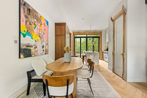 a view of a dining room with furniture a rug and wooden floor
