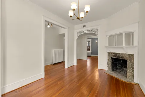 wooden floor fireplace and windows in an empty room