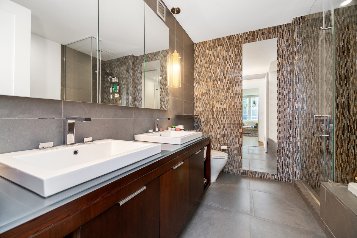 22 North 6th Street, Unit 18D Brooklyn, NY 11249 - Photo 5 of 9 a view of a bathroom with a sink and mirror