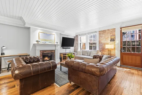 a living room with furniture a fireplace and a flat screen tv