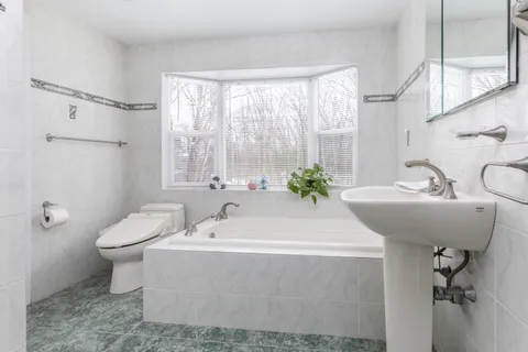 a bathroom with a sink and mirror with toilet