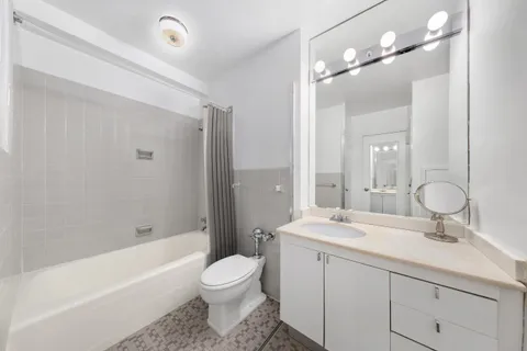 a bathroom with a double vanity sink toilet mirror and bathtub