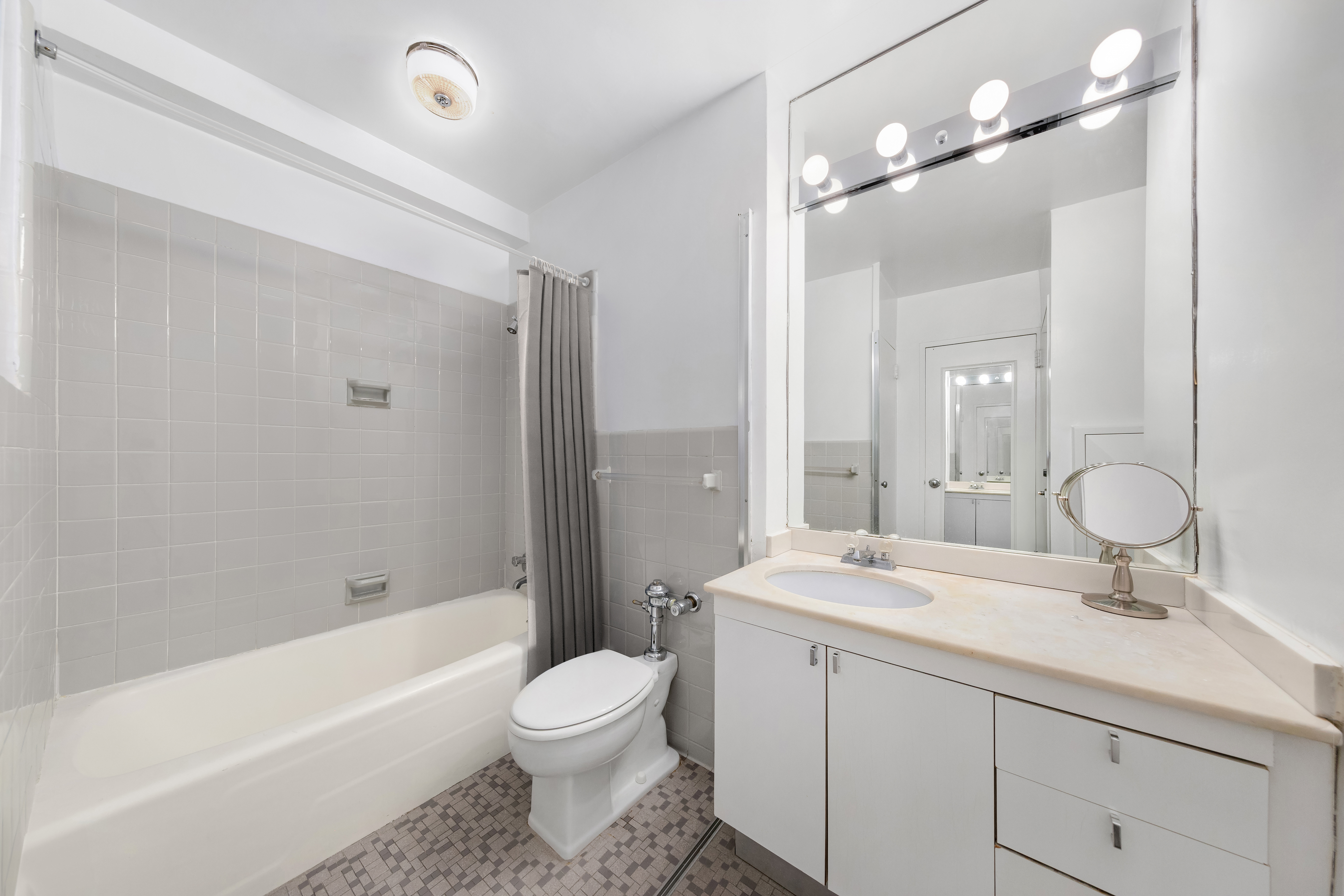 77 West 55th Street, Unit 16A Manhattan, NY 10019 - Photo 4 of 6 a bathroom with a double vanity sink toilet mirror and bathtub