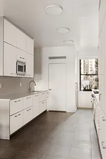 a large white kitchen with cabinets