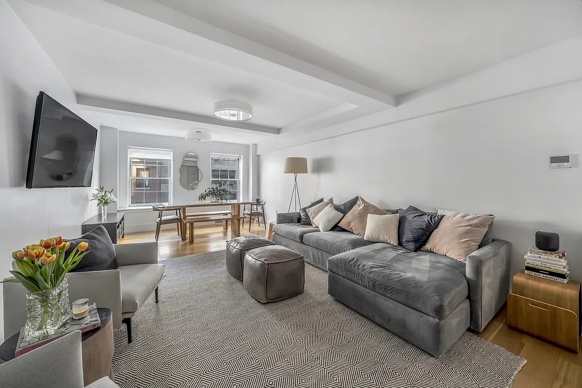 12 East 88th Street, Unit 6C Manhattan, NY 10128 - Photo 2 of 15 a living room with furniture and a flat screen tv