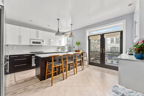 a large kitchen with stainless steel appliances kitchen island granite countertop a refrigerator a stove a sink dishwasher with a dining table and chairs