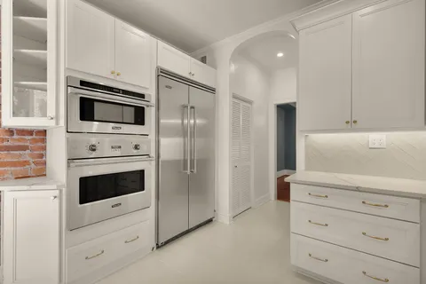 a kitchen with white cabinets and stainless steel appliances