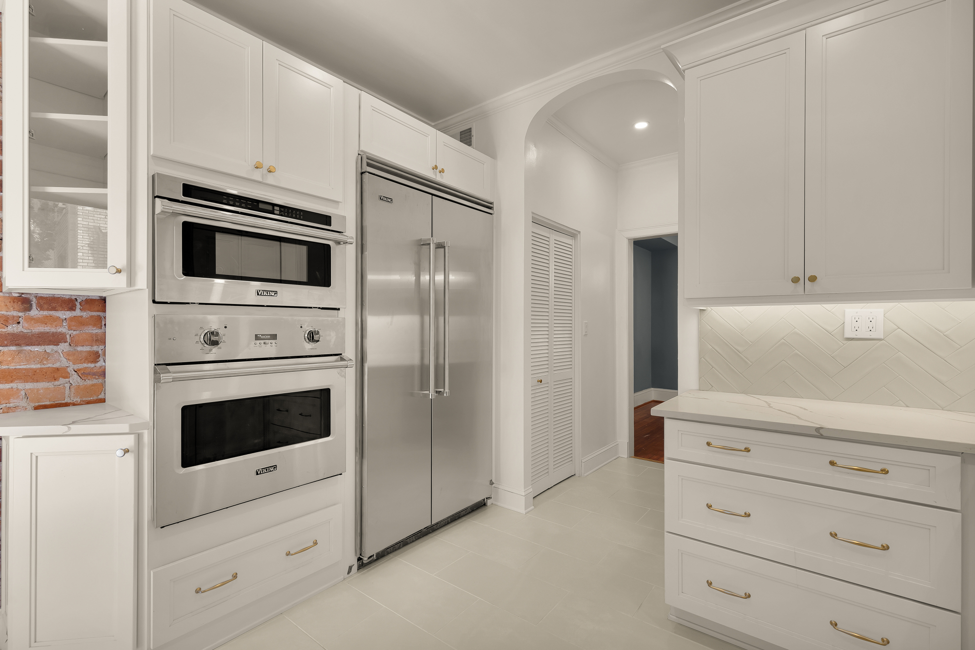 1737 Park Road Northwest Washington, DC 20010 - Photo 12 of 32 a kitchen with white cabinets and stainless steel appliances