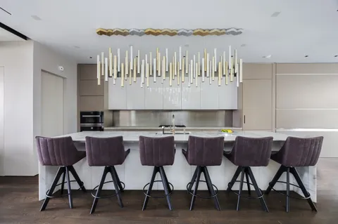a kitchen with a dining table chairs and wooden floor