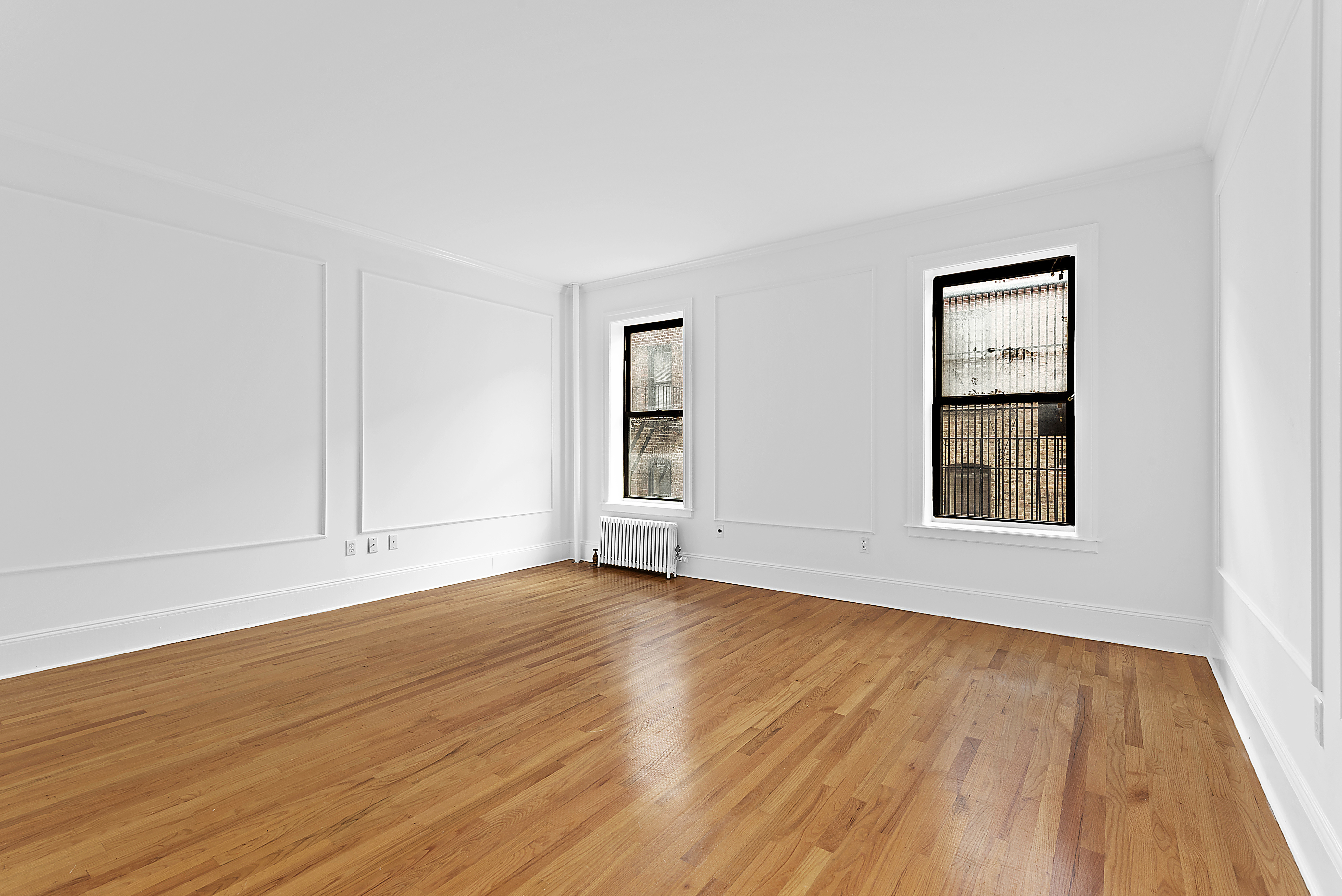 1240 Park Avenue, Unit 4C Manhattan, NY 10128 - Photo 3 of 9 a view of an empty room with wooden floor and a window