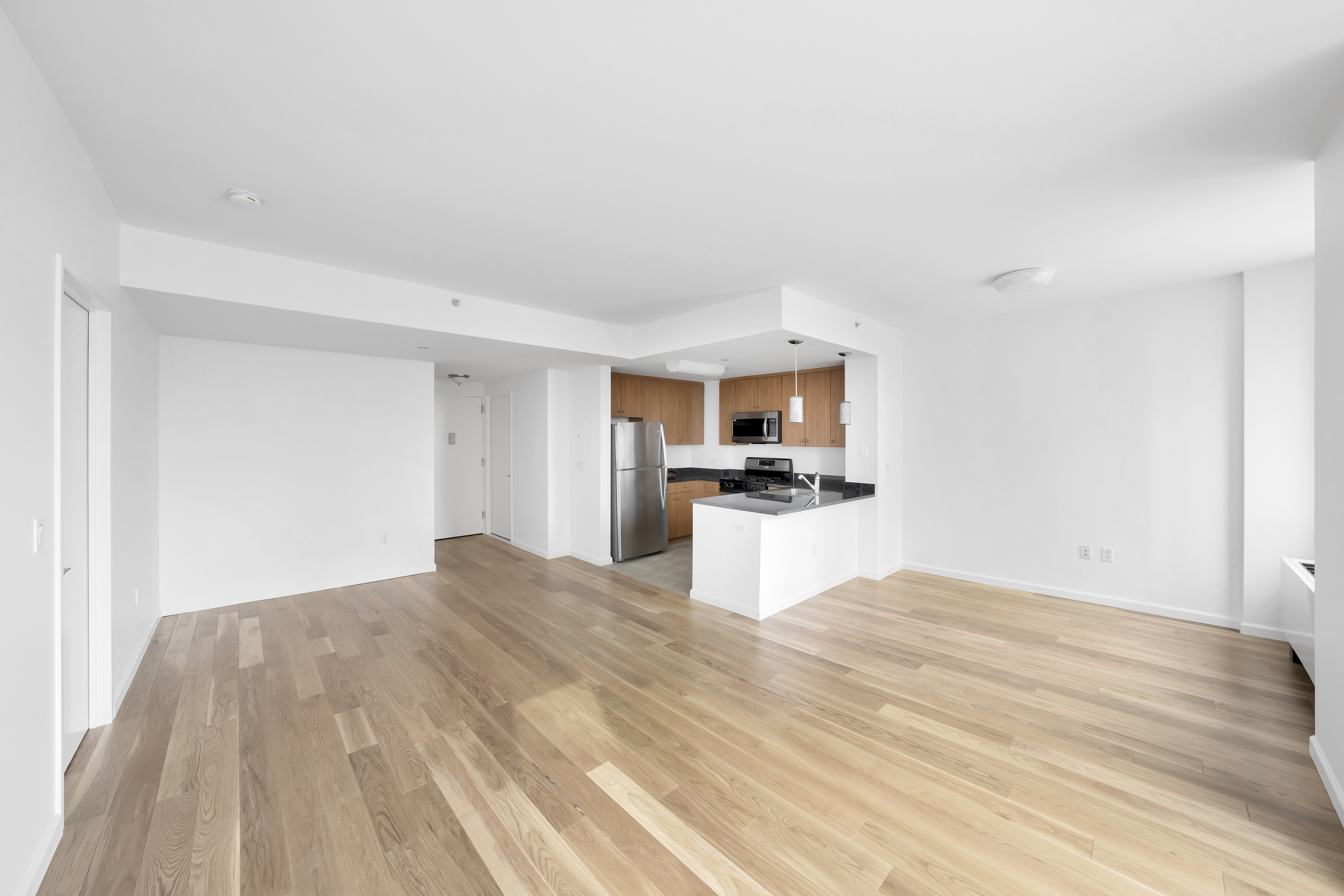455 Main Street, Unit 5K Manhattan, NY 10044 - Photo 4 of 12 a view of kitchen with refrigerator sink microwave and cabinets
