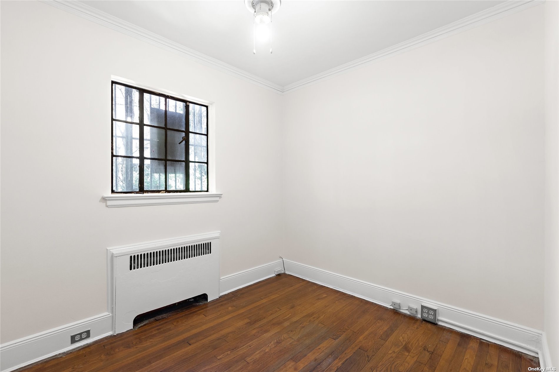 85-23 Edgerton Boulevard Queens, NY 11432 - Photo 12 of 36 a view of an empty room with wooden floor and a window