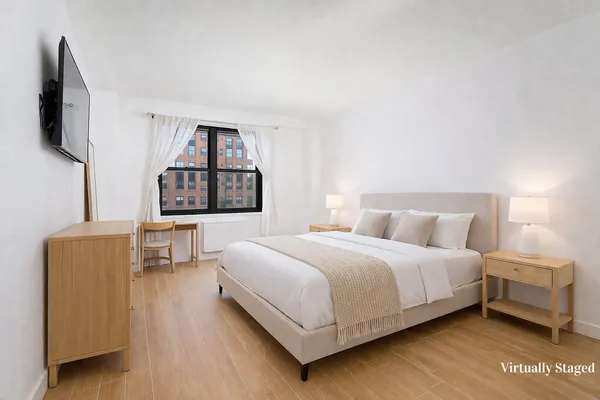 a bedroom with a bed wooden floor and window