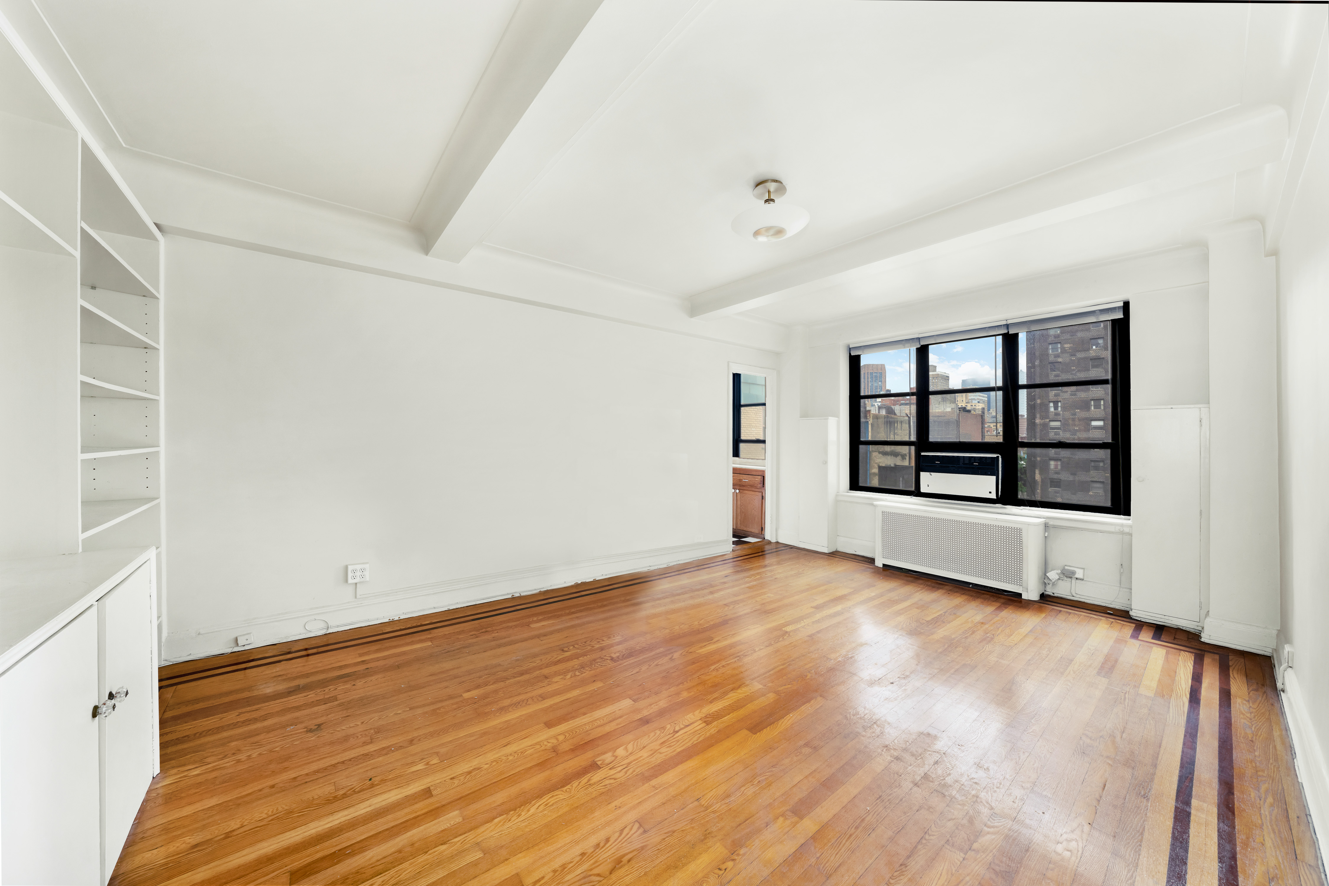 235 East 22nd Street, Unit 9M Manhattan, NY 10010 - Photo 3 of 15 wooden floor in an empty room with a window