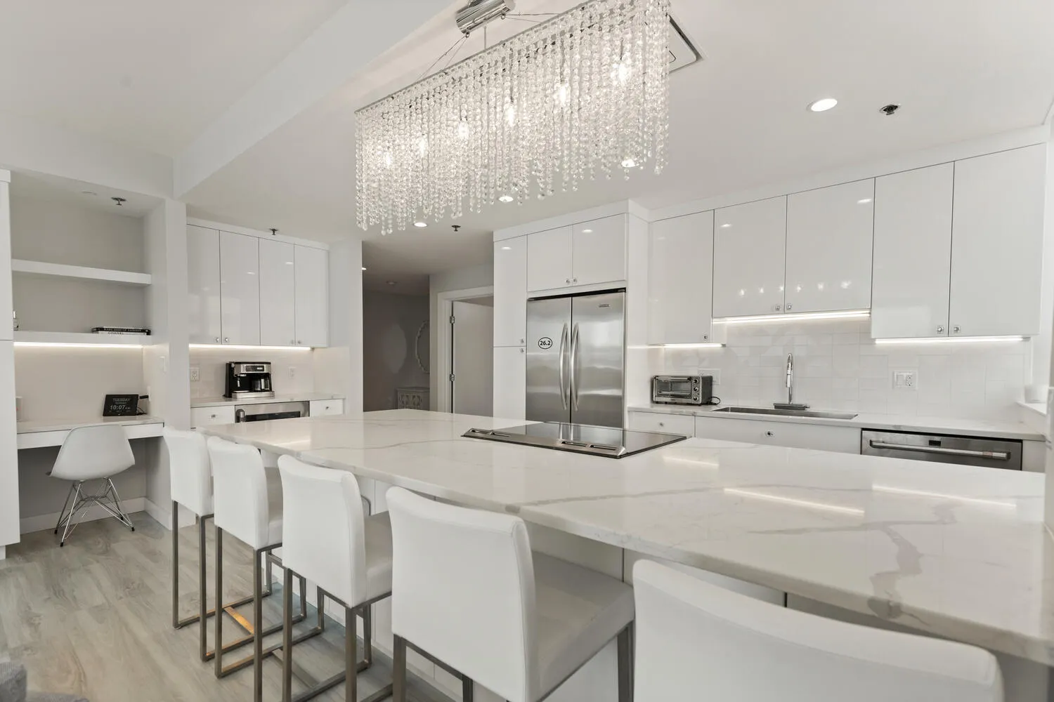 a kitchen with stainless steel appliances kitchen island granite countertop a table chairs and a refrigerator