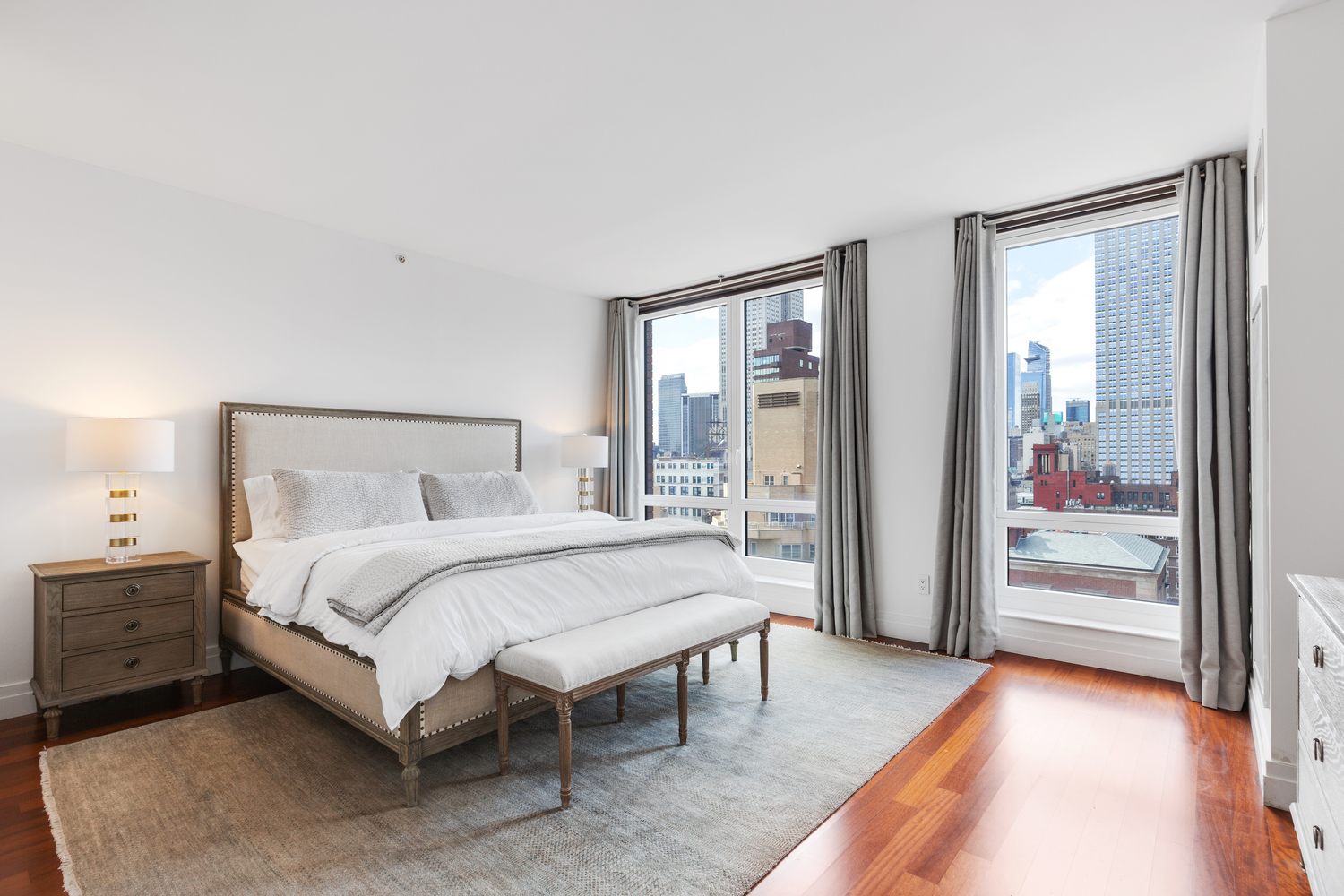 45 Park Avenue, Unit 2101 Manhattan, NY 10016 - Photo 4 of 10 a bedroom with a bed and a mirror