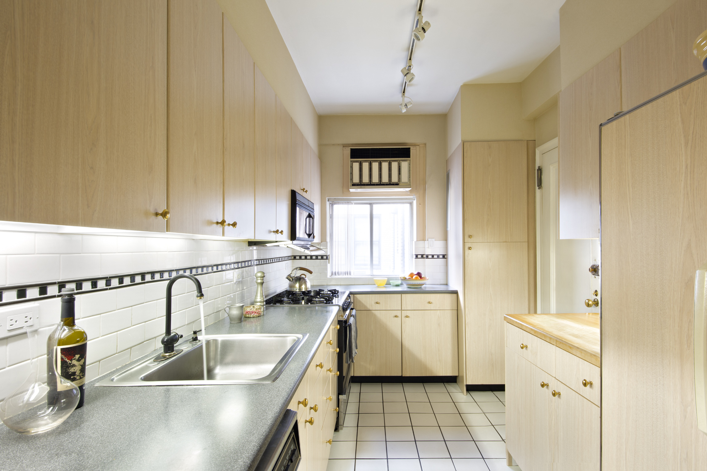 21 East 87th Street, Unit 11A Manhattan, NY 10128 - Photo 5 of 10 a kitchen with a sink appliances and cabinets