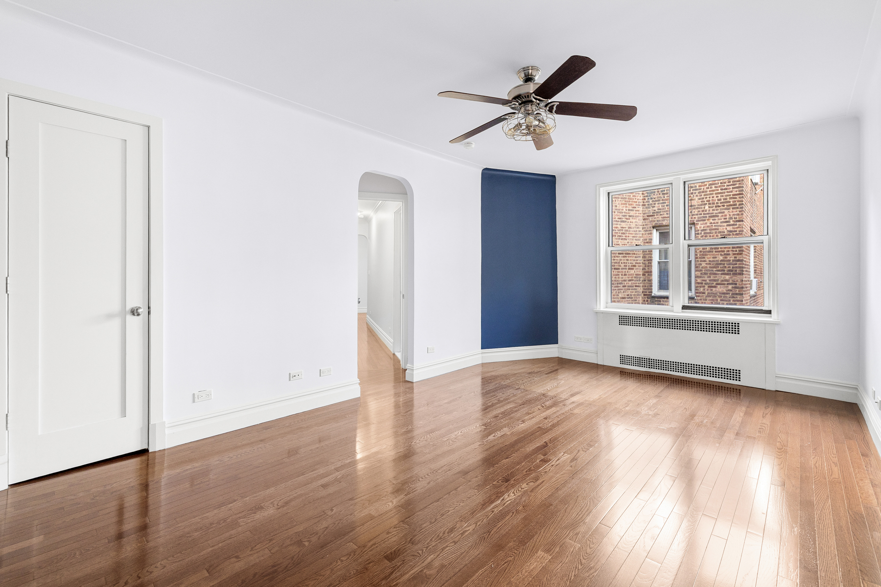 73-12 35th Avenue, Unit D56 Queens, NY 11372 - Photo 6 of 15 a view of empty room with wooden floor and window