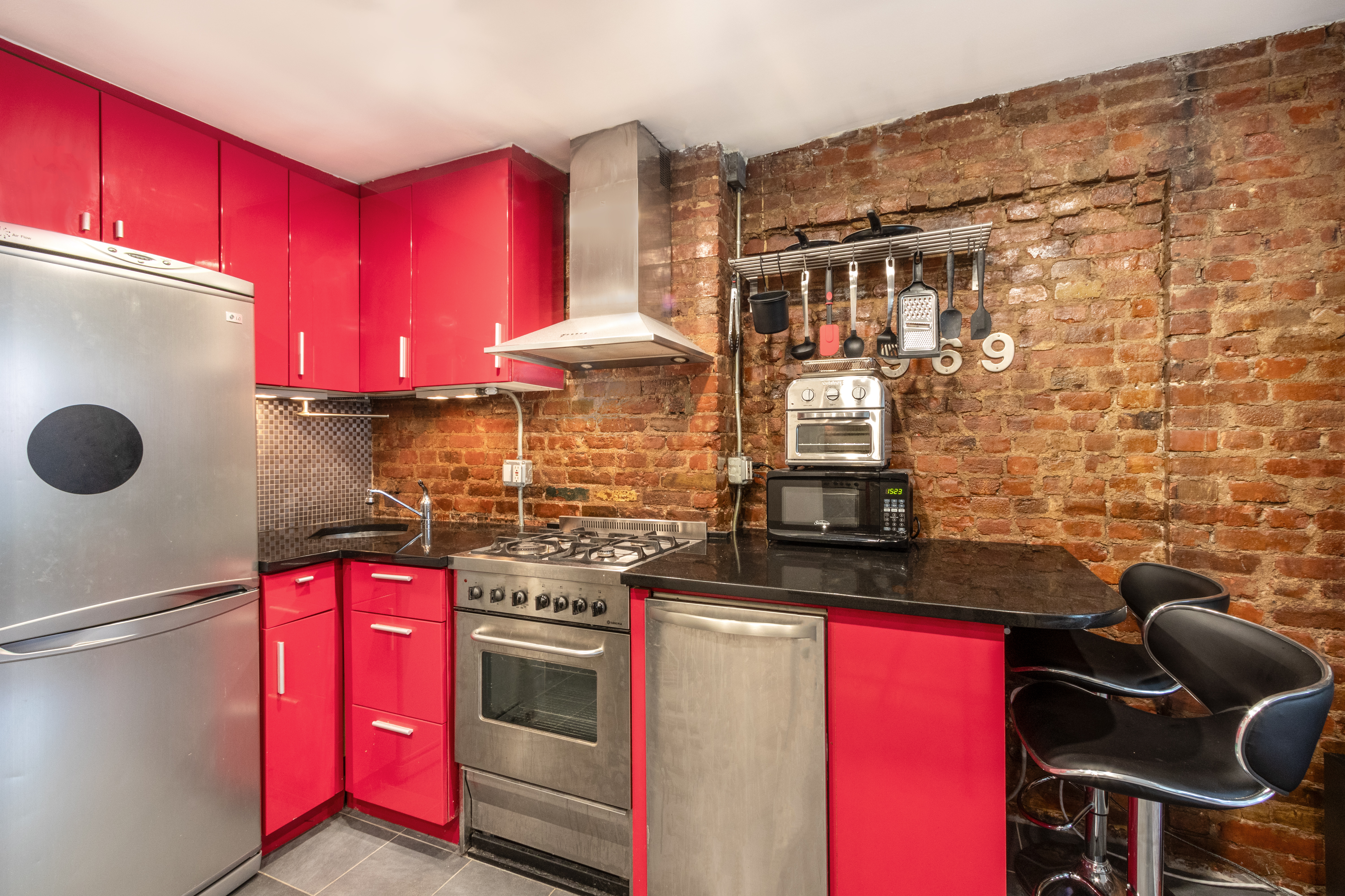 88 East 3rd Street, Unit 15 Manhattan, NY 10003 - Photo 4 of 6 a kitchen with a stove and a microwave