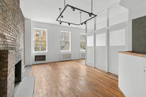 a view of empty room with wooden floor and fireplace